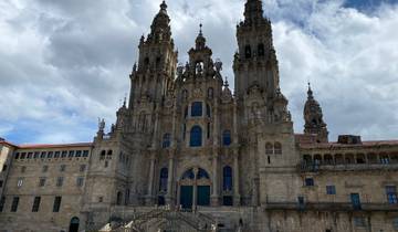 Ornate cathedral with baroque architecture under a partly cloudy sky.