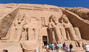 The Great Temple of Abu Simbel with large statues and gathered tourists.