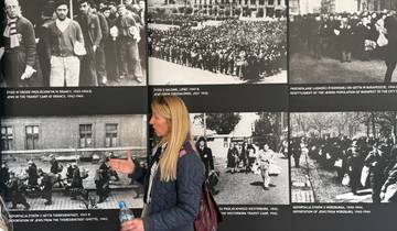Woman observing historical photographs on display.