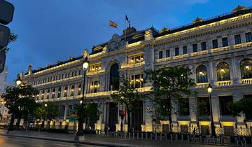 An illuminated historic building in an urban setting at night.