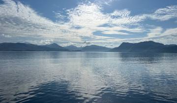 Calm sea with reflections under a bright sky.