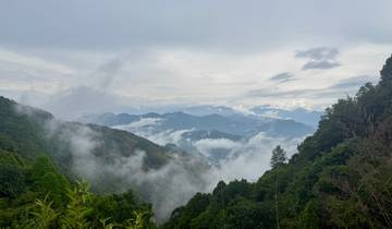 Scenic view of lush green mountains and clouds.