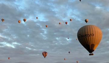 Hot air balloons floating over scenic valleys during sunrise.