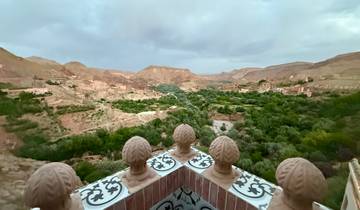 Panoramic view of a lush valley landscape with mountains.