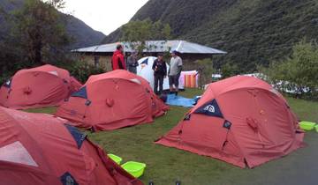 A campsite with red tents set up in a scenic area.