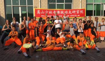 Group practicing martial arts in front of a banner.