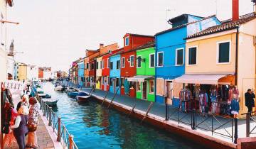 Colorful buildings along a canal with boats.