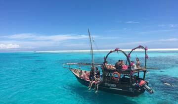 Group of people relaxing on a boat in turquoise blue water.