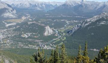 Valley view with a river and mountains in the distance.
