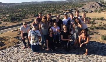 Group standing atop a stone structure with a scenic view.