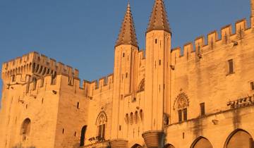 Historic building with pointed towers at sunset.