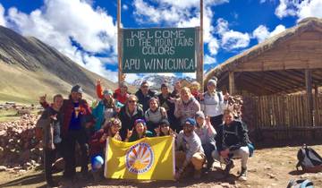 A group of people posing with a flag in a mountainous region.