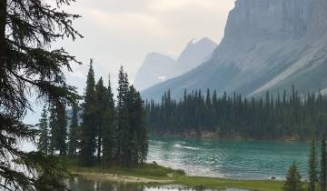 A picturesque lake with mountains and pine trees.