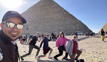 Group of tourists at the Great Pyramid with bright sun.