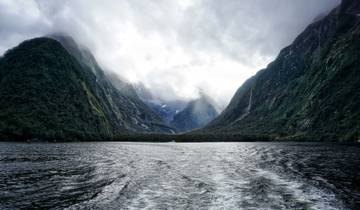 Stunning fjord landscape with misty mountains and a body of water.