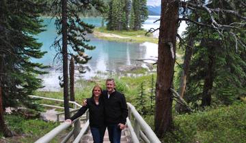 Couple posing in a scenic area with a turquoise lake.