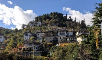 Traditional stone houses on a hillside under clear blue skies.