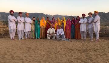 Large group in traditional attire posing outdoors.