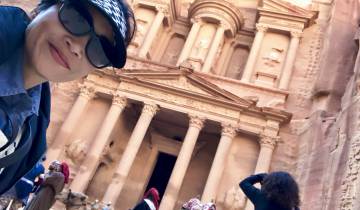 Woman taking a selfie at Petra's iconic rock face.