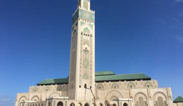 A mosque with a tall minaret against a clear blue sky.