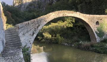 Old stone bridge over a river in a mountainous area.