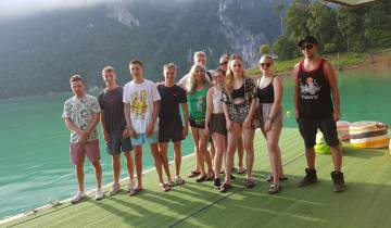 Group of young people posing on a floating dock on a lake.