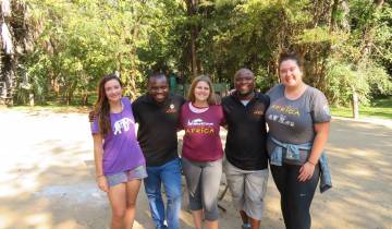 Group photo of people posing with Acacia Africa shirts.