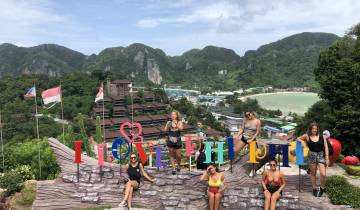 Group of women posing with 'I Love Phi Phi' sign.