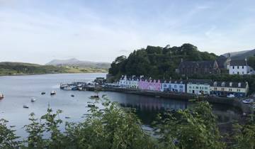 Colorful houses by a waterfront with hills.