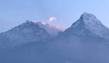 Snow-covered mountain peaks under a twilight sky.