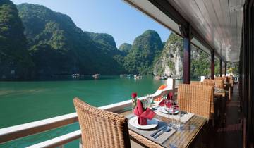 Dining setup on a cruise ship with a view of karst mountains