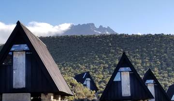 A series of mountain huts with a peak in the background.