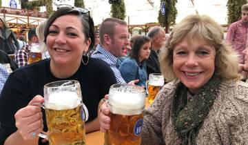 Two women enjoying large beer mugs at a beer festival.
