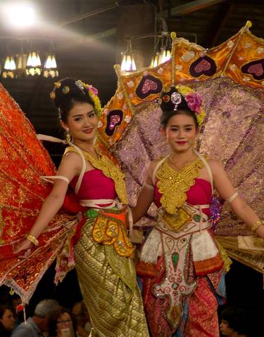 Two women in traditional, colorful Thai costumes.