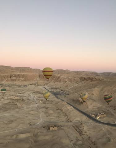 Hot air balloons soaring over a desert landscape.