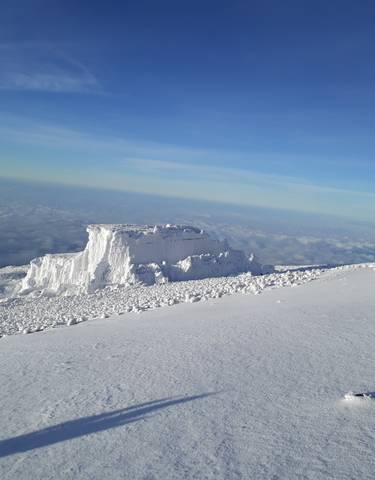Icy landscape at high altitude with vast sky view.