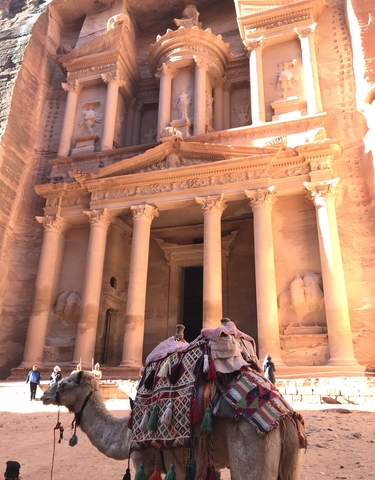 Front view of The Treasury at Petra with camel riders in foreground.