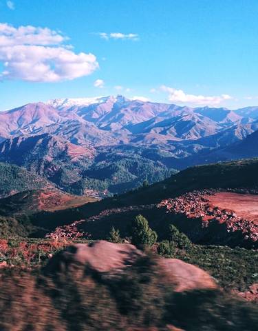 Panoramic view of mountain ranges under blue sky.