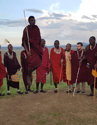 Group of traditionally dressed Maasai men performing a dance.