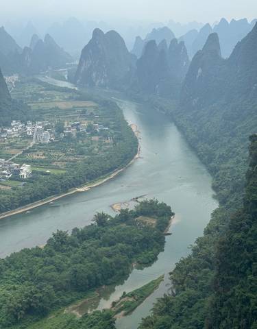 A river winding through lush green landscapes and mountains.