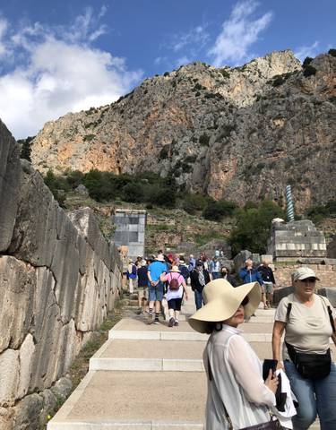 Tourists walking on ancient stone steps outside.