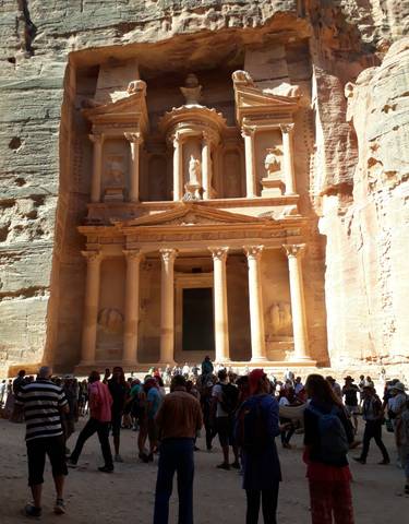 Petra Treasury with tourists at the base of the facade.