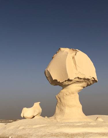 Oddly shaped white rock formations against a clear sky.