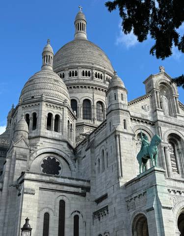 A detailed close-up of the Sacré-Cœur Basilica against a blue sky.