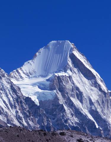 Snow-capped mountain peak against a clear blue sky.