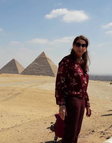 A woman standing in front of the pyramids of Giza.