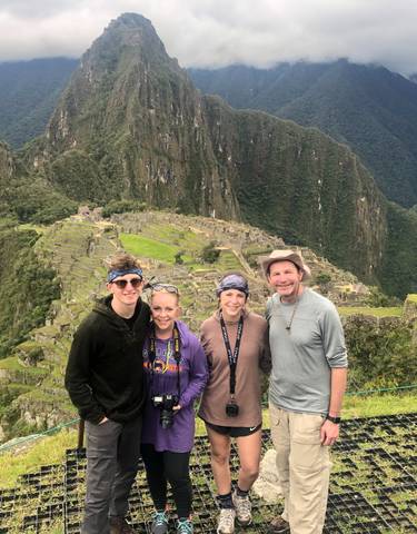 Family portrait at Machu Picchu with the ruins in the background.