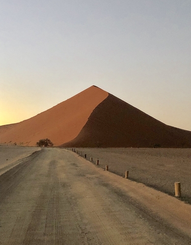 Massive sand dune in the desert during sunset.