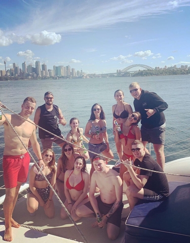 People enjoying a boat ride with the Sydney skyline in the background.