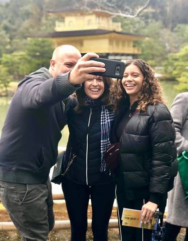 Group of friends taking a selfie in a park-like setting.